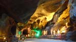 the inside of Ramayana Cave is lit with statues of Hindu deities
