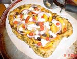 Tam's grilled mango pizza with tomato sauce and pesto-lined crust topped with chevre (goat cheese), red onions and cherry tomatoes