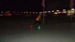 a kid whizes by with glow-in-the-dark roller blade wheels
