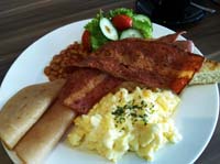 a hearty breakfast serving at Arcadia Hotel - bacon, scrambled eggs, beans, ham, toast, greens